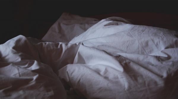 An empty bed in darkness