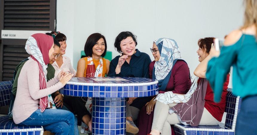 A group of people sit around a table laughing